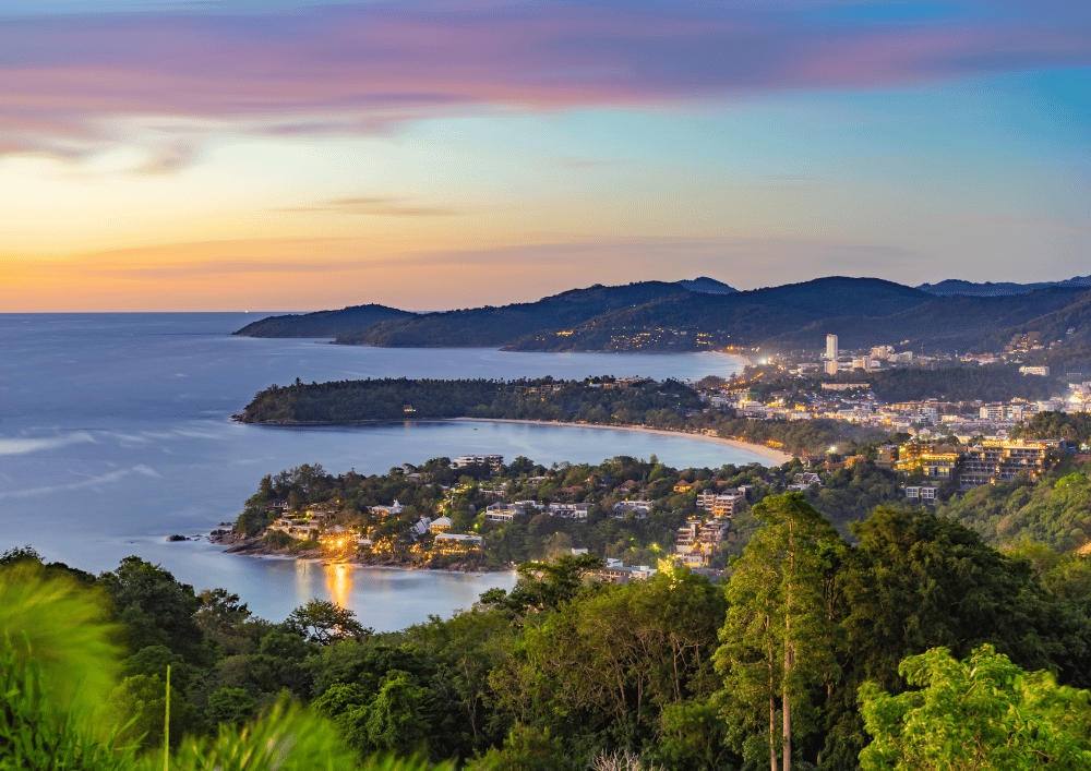 Vista panorâmica de Phuket ao entardecer com baía, praia e luzes da cidade