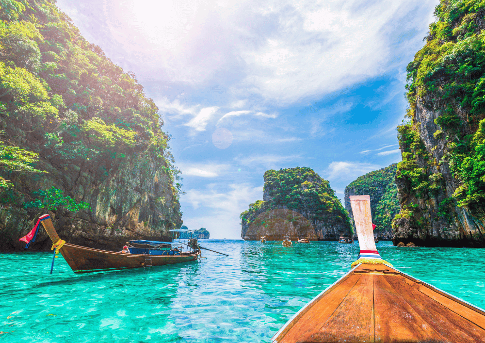 Barco long-tail navegando entre falésias e águas cristalinas em Phi Phi, Tailândia